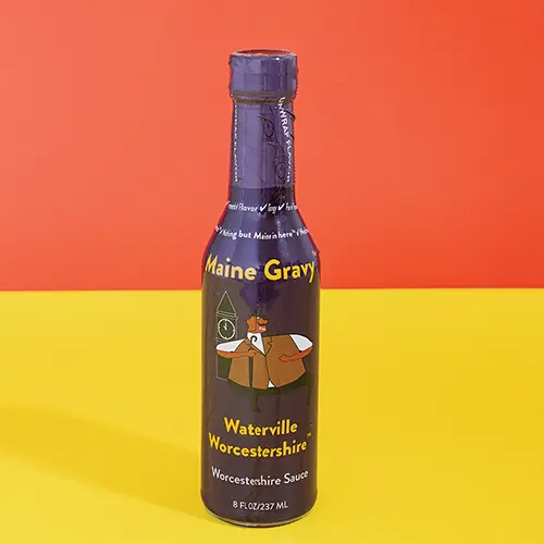 Maine Gravy Waterville Worcestershire sauce bottle on a colored background