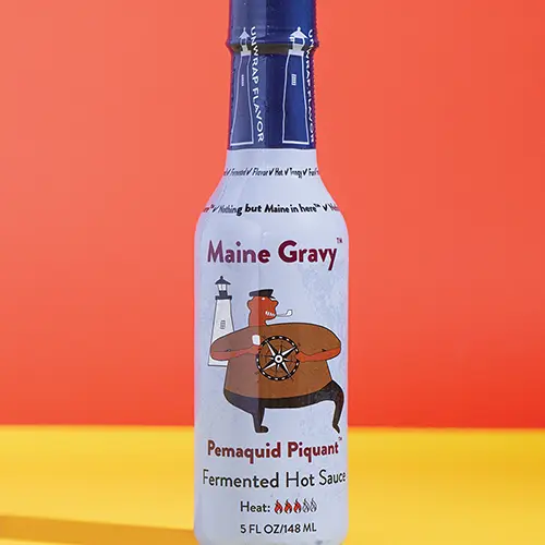 Maine Gravy Pemaquid Piquant hot sauce bottle on colored background